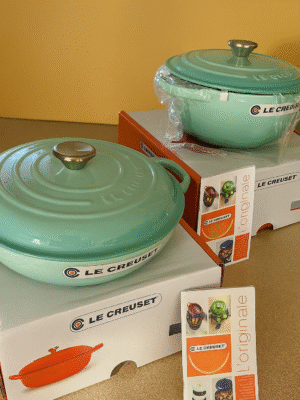 Le Creuset 26cm shallow and deep pots in mint, shown with lids and booklets on display