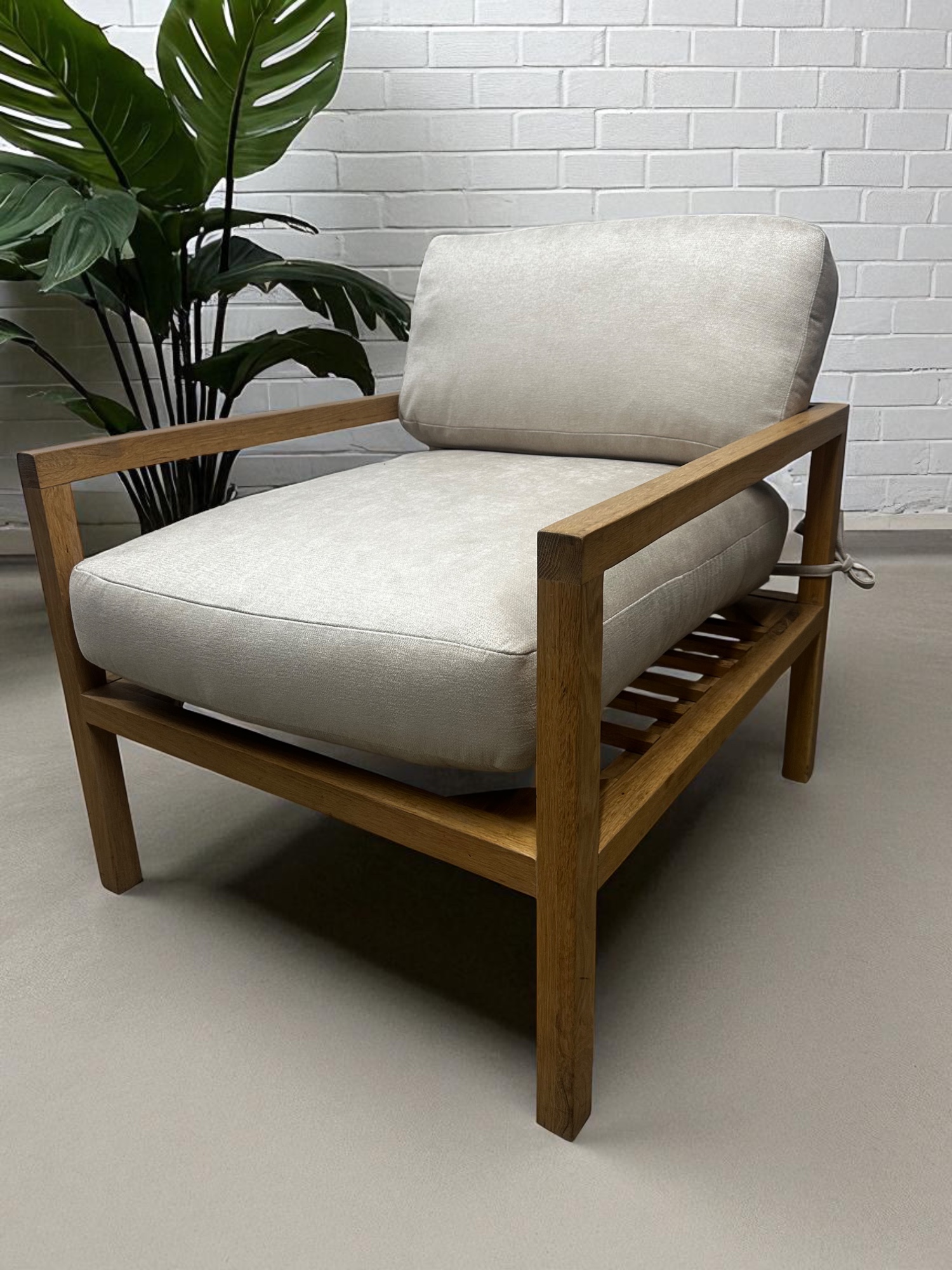 Solid oak lounge chair with neutral fabric cushions – minimalist Scandinavian design
