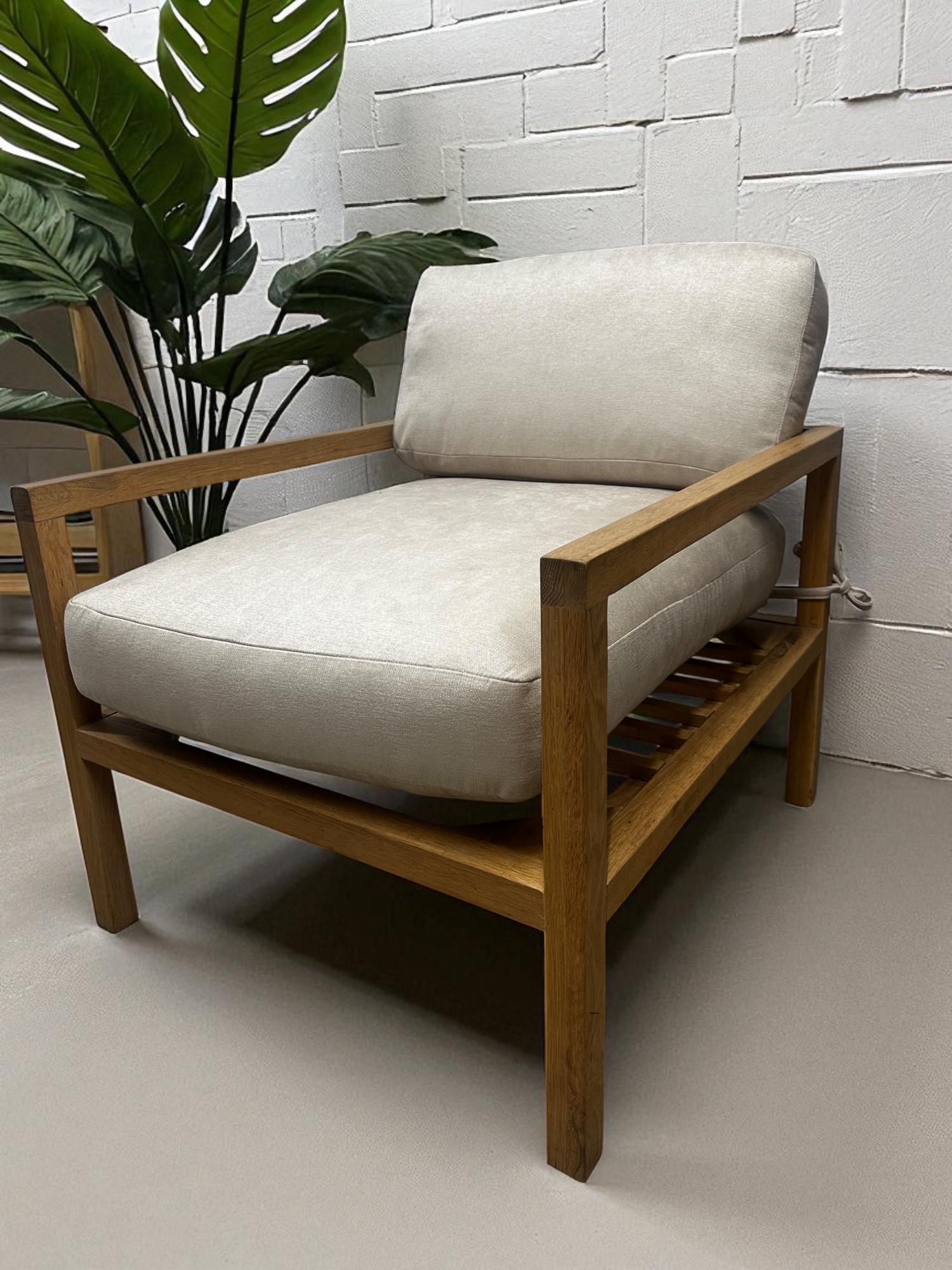 Solid oak lounge chair with neutral fabric cushions – minimalist Scandinavian design