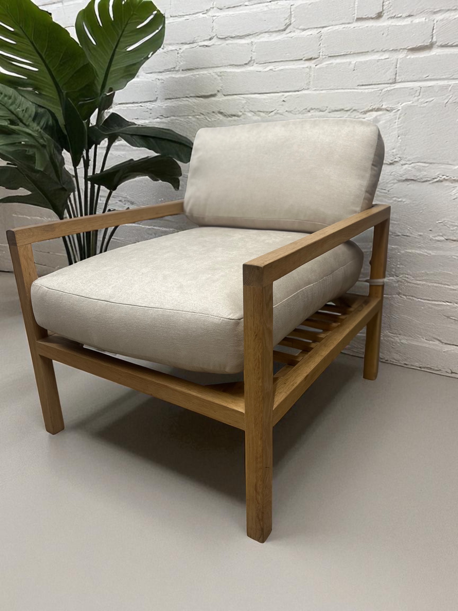 Solid oak lounge chair with neutral fabric cushions – minimalist Scandinavian design full view
