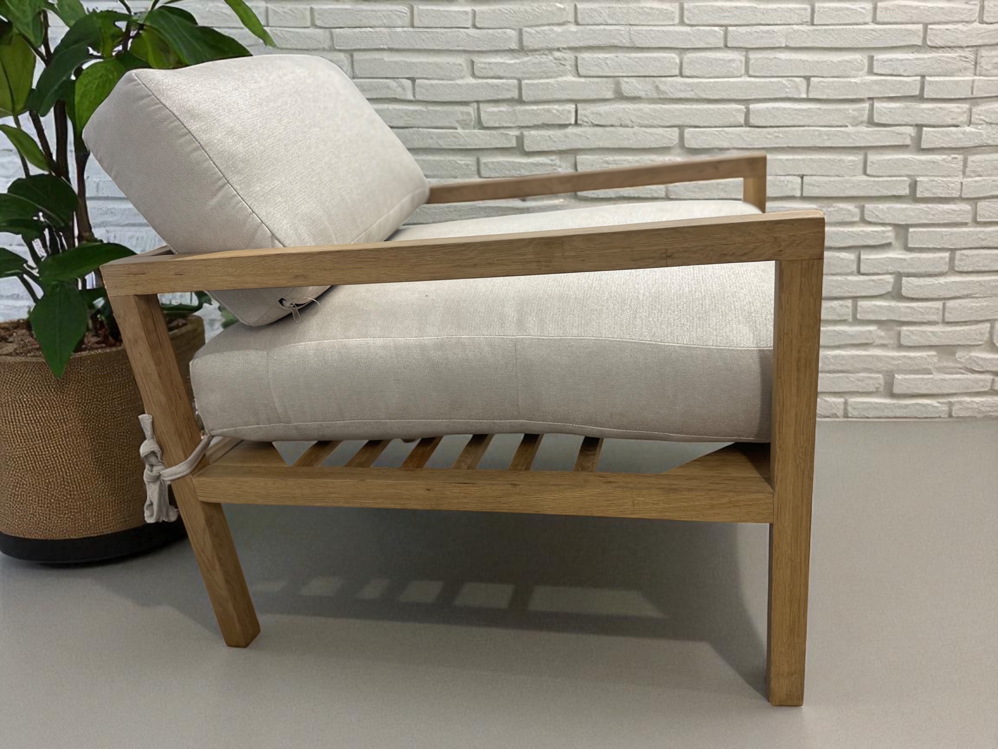 Solid oak lounge chair with neutral fabric cushions – minimalist Scandinavian design side profile