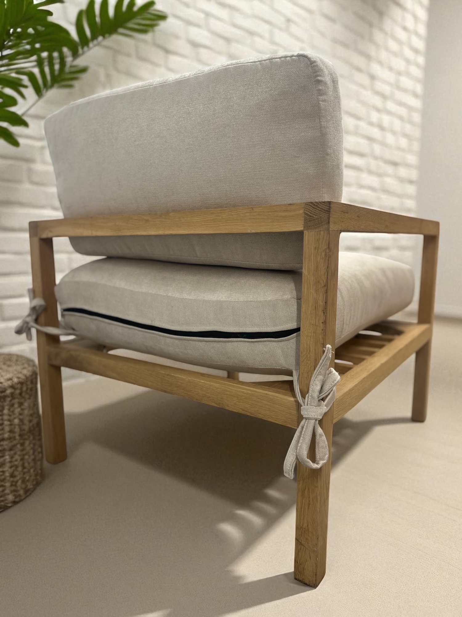 Solid oak lounge chair with neutral fabric cushions – minimalist Scandinavian design back