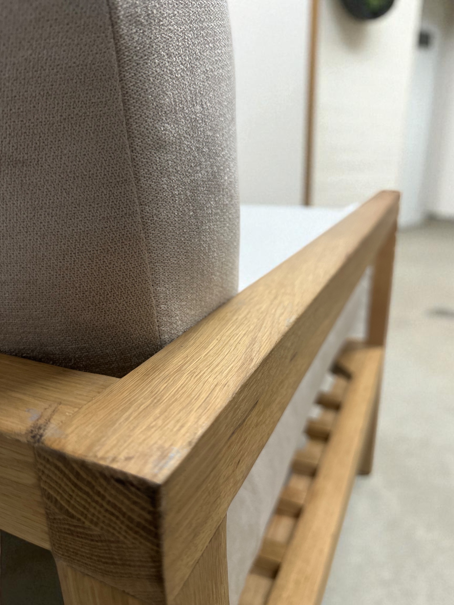 Solid oak lounge chair with neutral fabric cushions – minimalist Scandinavian design zoomed in arm