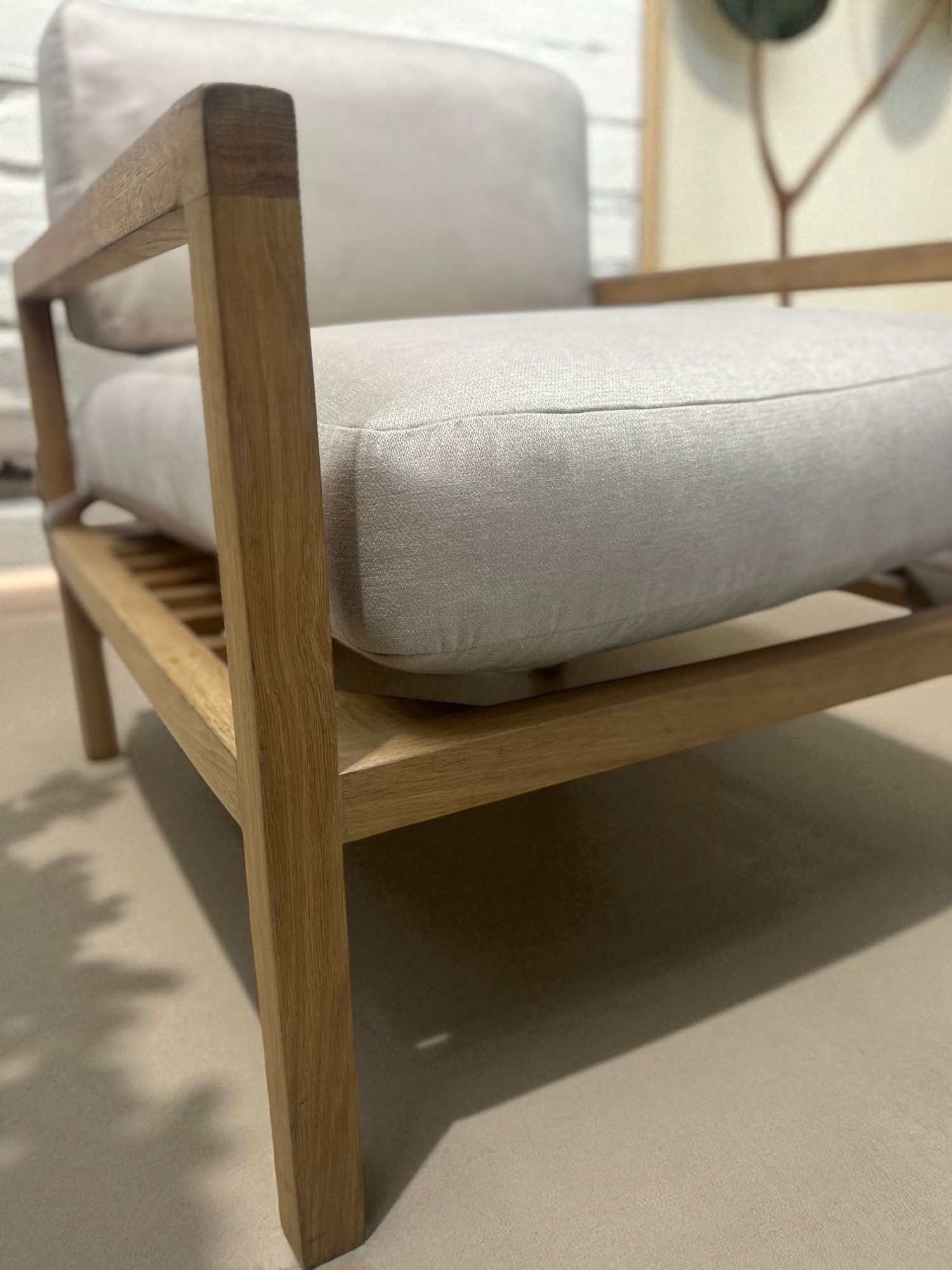 Solid oak lounge chair with neutral fabric cushions – minimalist Scandinavian design